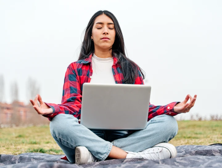 lady_doing_meditation_while_taking_guidance_from_laptop